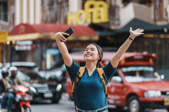 Happy tourist backpacker woman making selfie video in city