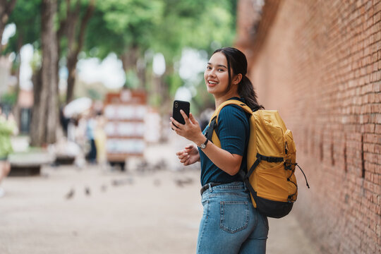 Young woman traveling using smartphone in city