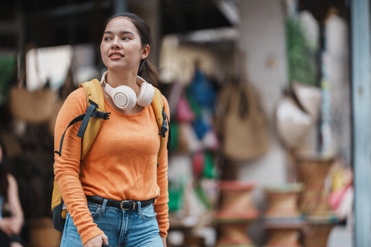 Young woman backpacker exploring urban street market
