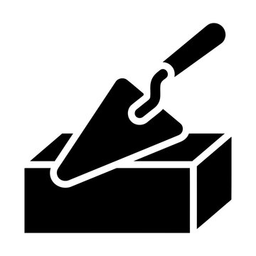 trowel and brick glyph icon