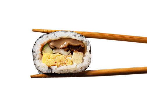 Chopsticks Holding a Piece of Japanese Futomaki Thick Sushi Roll Isolated on White Background