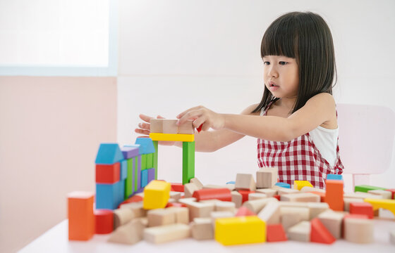 Little asian girl hands play blocks in classroom. Learning by playing education group study concept. International pupils do activities brain training in primary school background banner