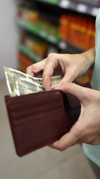 Close up view of leather wallet, woman hands counting cash money (Indian rupee INR banknotes) for shopping in supermarket. Calculating budget to spend in grocery store. Financial planning concept.