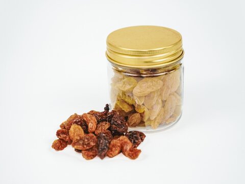 Dried raisins and water isolated white background closeup