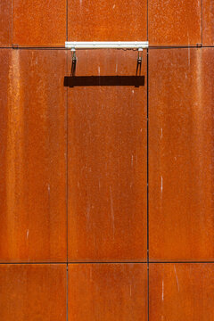 Industrial weathered corten steel panels with rusty orange texture and lighting fixture