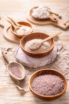 Psyllium husk and powder, xanthan and guar gum in wooden bowls and spoons on a rustic table