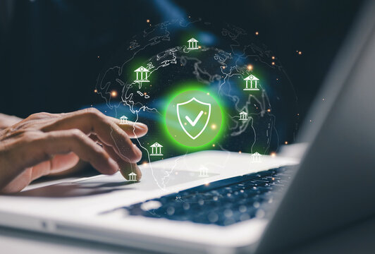Global financial security concept with user working on laptop and virtual shield over world banking network, representing secure digital finance and protected transactions worldwide.