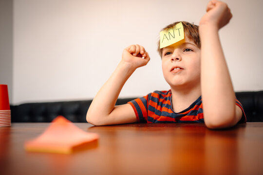 Kid playing guessing game with sticky note