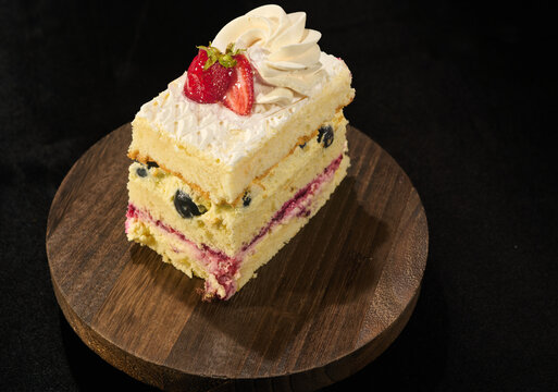 slice of blueberry and huckleberry fruit cake with white fluffy cream