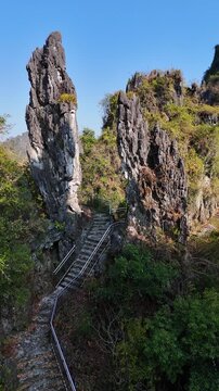 Vertical Video: A cluster of unique karst stone pillars rising from the rural landscape with scattered trees and open fields