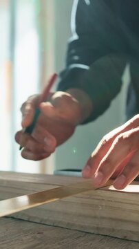 Wood, measurement and hands of carpenter in workshop for design process on furniture manufacturing. Pencil, man and artisan with t square for length precision on timber project with diy in factory.