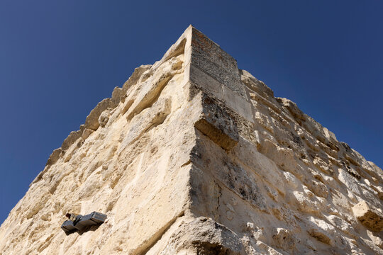 Muro in pietra leccese ad angolo con capochiave sulla parete sinistra e sfondo cielo