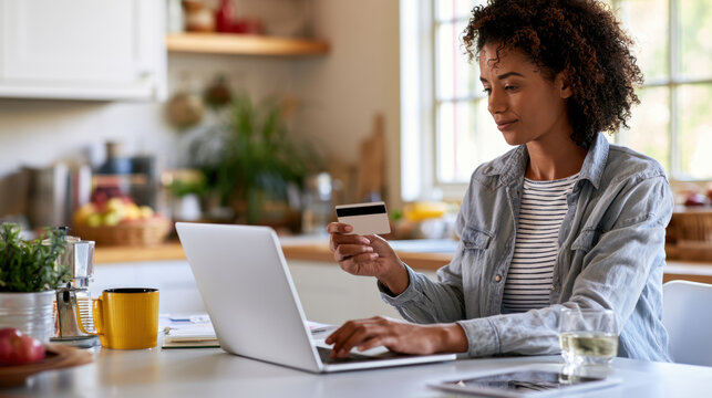 Woman Holding Credit Card Entering Payment Details on Laptop at Home Kitchen