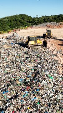 Flock of Birds Flying Over Massive Landfill with Exposed Waste and Garbage. Bigua&ccedil;u, Santa Catarina, Brazil. Aerial View.