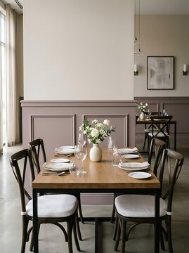 Elegant dining room interior with wooden table, plush chairs, pastel pink and beige walls, and fresh flowers