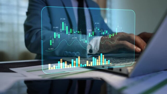 Holographic stock market data chart graph dashboard on the virtual screen, Businessman using a laptop with transparent financial charts, candlestick data and bar graphs over office documents