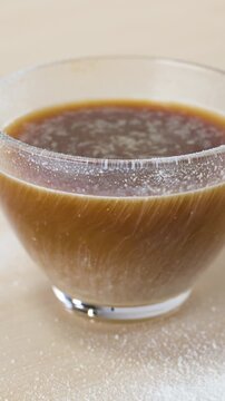 Dairy Alternative Cream Swirling in Glass Mug of Black Coffee
