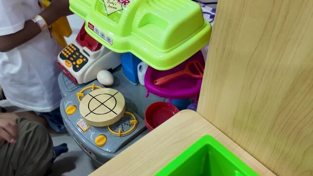 Colorful children play kitchen toy set with miniature utensils and stove in daycare.
