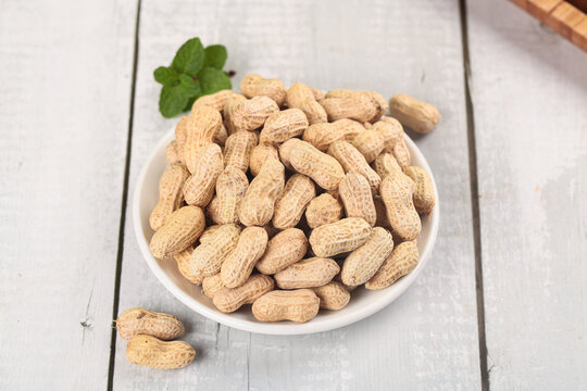 Raw Peanuts in Shells on Wooden Background - Healthy Natural Snack Food Ingredients