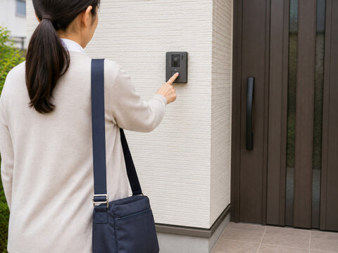 Female Home Visit Worker Pressing Door Intercom at a Residential House