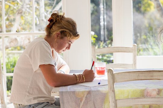 young woman drawing at table in light filled room
