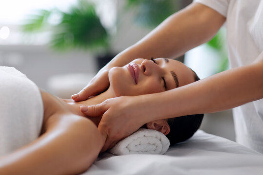 Female client receiving gentle cervical massage on spa bed, experiencing deep relaxation, stress relief and complete body rejuvenation