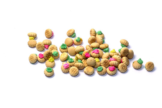 A mound of traditional colorful iced gem biscuits with hardened pastel icing topping, isolated against a clean white background.