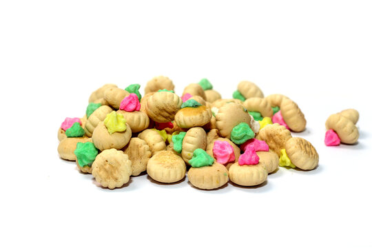 A mound of traditional colorful iced gem biscuits with hardened pastel icing topping, isolated against a clean white background.