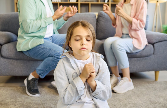 Child parents family conflict argument causes anxiety. Upset girl sits in front as parents argue on sofa, illustrating stress at home and family strain. Clear concept of child anxiety.