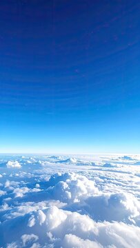 View from above the clouds under a clear blue sky.