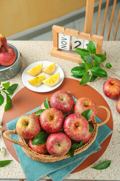 Fresh Red Apples from Daliangshan Aksu Regions in Wicker Basket with Fruits on Kitchen Table
