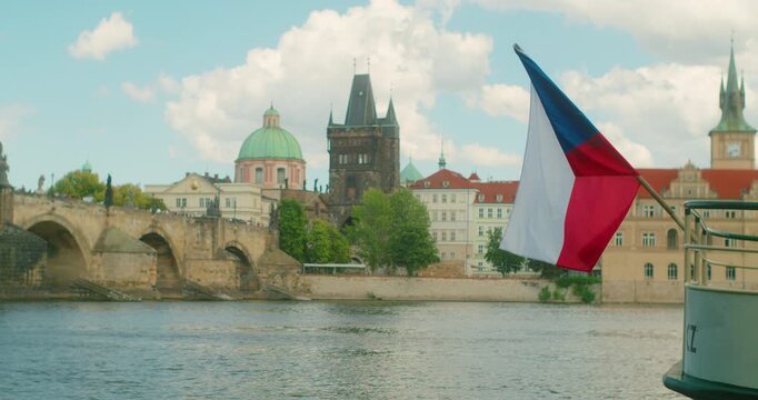 Czech flag waves above Vltava River highlighting Prague heritage and national identity