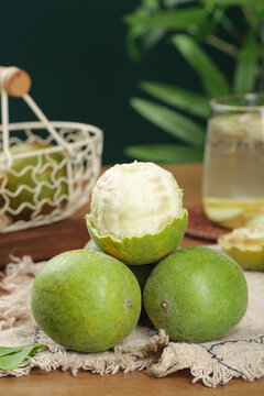 Fresh Luo Han Guo Monk Fruit with One Cut Open Showing White Flesh on Rustic Burlap Natural Lifestyle Setting