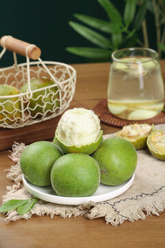 Fresh Luo Han Guo Monk Fruit Studio Photo with Tea Glass and Decorative Elements on Wooden Table
