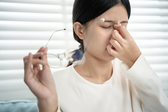 Eye problems, Asian women use hand cover eyes due to eye irritation, eye rubbing, dry, eye pain after look mobile phone long time in low light, migraine, headache, blurred vision, photophobia