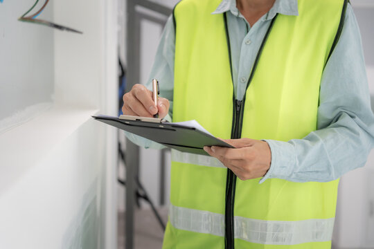 inspector or engineer is inspecting construction and quality assurance new house using a checklist. Engineers or architects or contactor work to build the house before handing it over to the homeowner