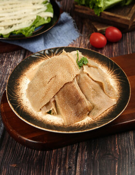 Traditional Hot Tripe Soup with Fresh Herbs in Ceramic Bowl on Wooden Table