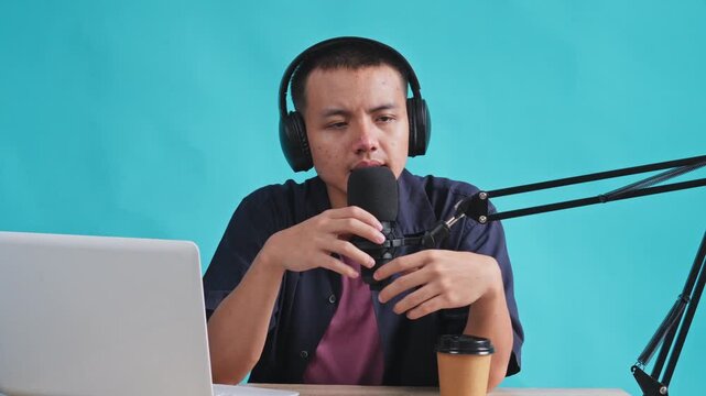 Presenter setting up audio gear, testing sound, and adjusting mic arm while sitting at desk