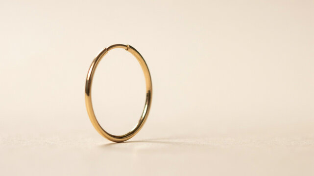 Simple Gold Hoop Earring: A minimalist gold hoop earring, a symbol of understated elegance and timeless style, rests on a soft, neutral background.