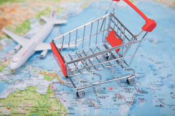 Mini shopping cart and airplane on world map for global shopping and travel concept © PhamHong