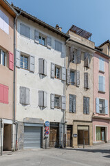 Fototapeta premium old traditional buildings on bending street in town central district, Digne, France