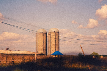 Cinematic vintage illustration of concrete silo towers on a rural farm © katamount
