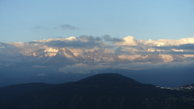 Snow-Capped Mountains Above Clouds at Dusk