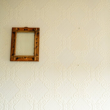 Ornate wooden frame on decorative textured wall with intricate patterns