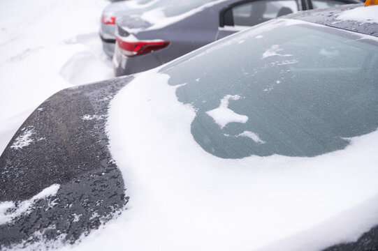 Snow-covered cars in winter parking lot after heavy snowfall