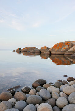 rocky shoreline pebbles calm water reflection seascape