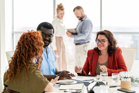 Happy diverse colleagues brainstorming in a bright office