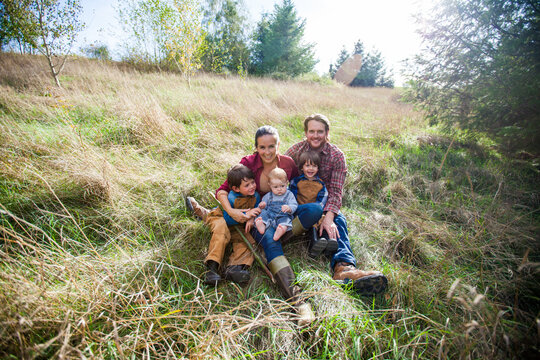 Happy family of five relaxing in a sunny field