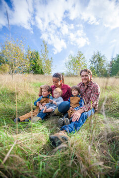Smiling family of five posing for a portrait outdoors