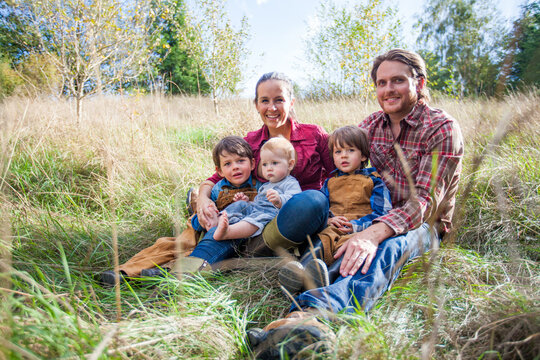Happy family of five posing in a sunny field